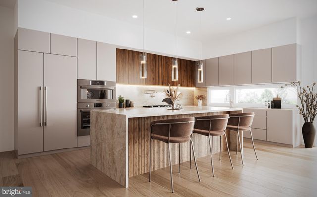 a kitchen with stainless steel appliances granite countertop a stove a refrigerator a microwave a sink and white cabinets with wooden floor