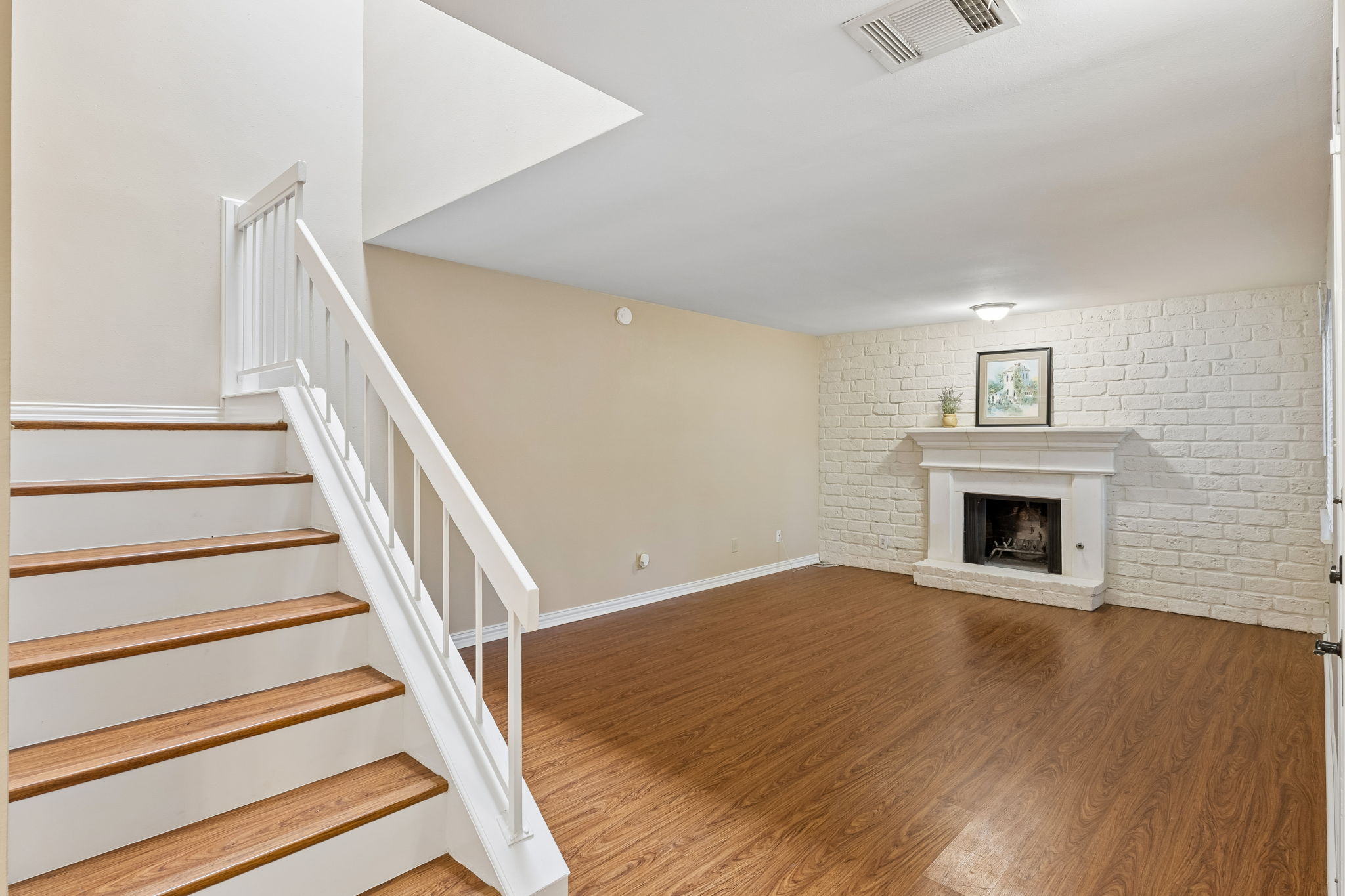 8340 Fathom Circle, Unit 103 Austin, TX 78750 - Photo 8 of 30 a view of an empty room with wooden floor fireplace and a window