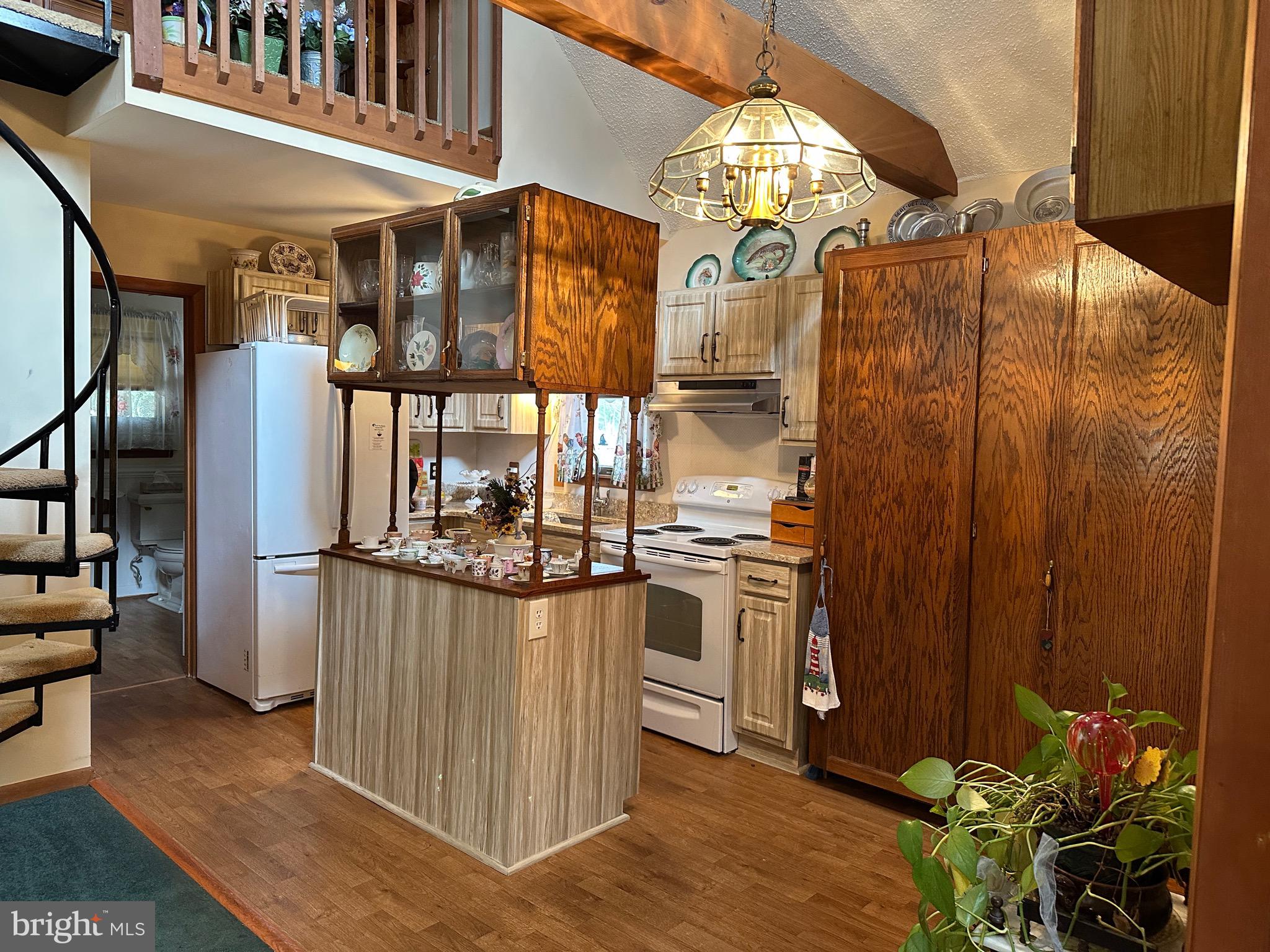 22887 Sycamore Drive Lewes, DE 19958 - Photo 31 of 38 a view of a kitchen with stainless steel appliances granite countertop a stove a refrigerator and a dining table with wooden floor