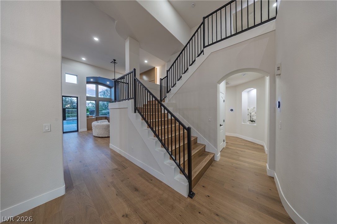 8800 Lusso Las Vegas, NV 89134 - Photo 37 of 85 Stairs with a high ceiling, arched walkways, and wood-type flooring