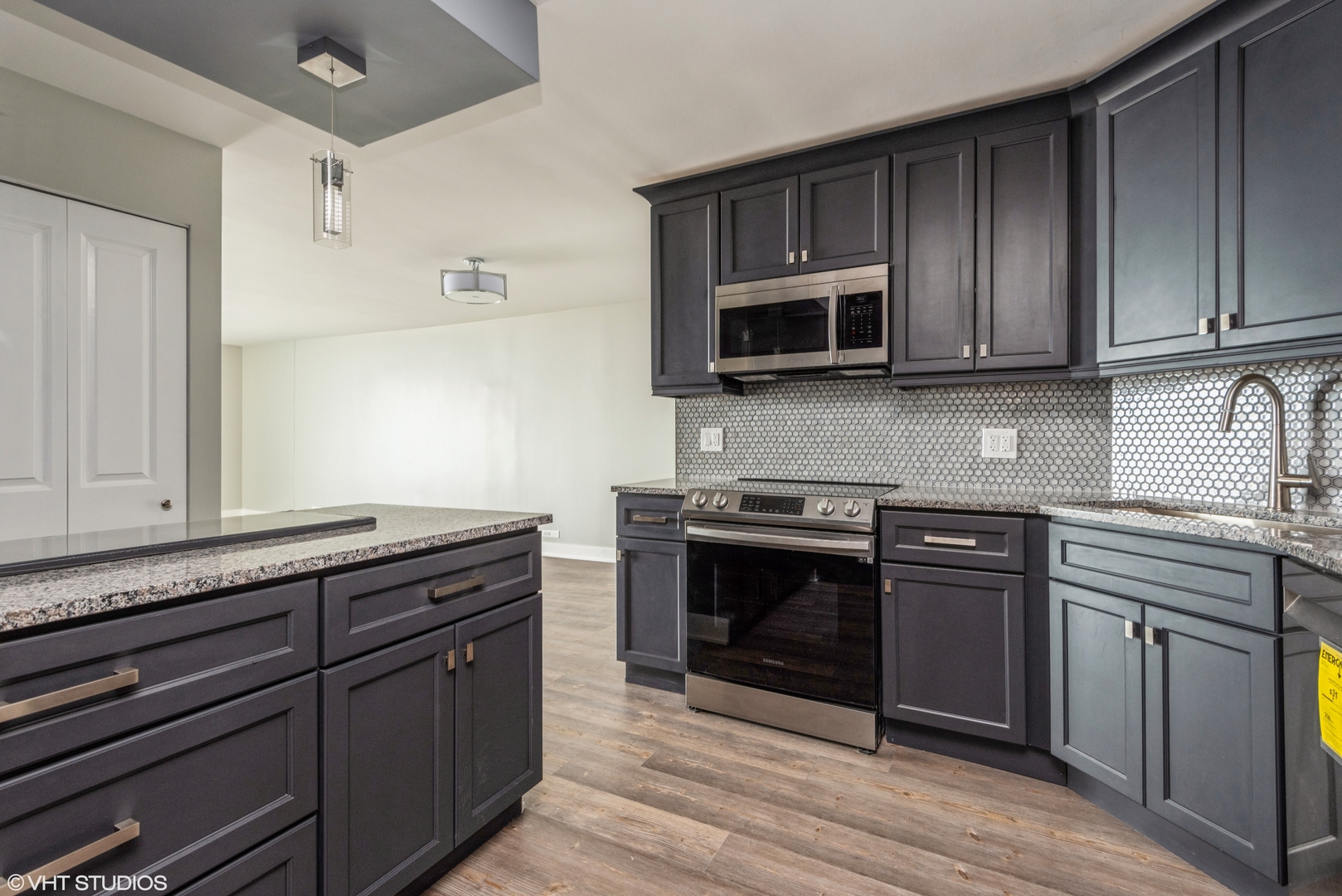 6033 North Sheridan Road, Unit 43D Chicago, IL 60660 - Photo 2 of 16 a kitchen with granite countertop wooden cabinets and stainless steel appliances