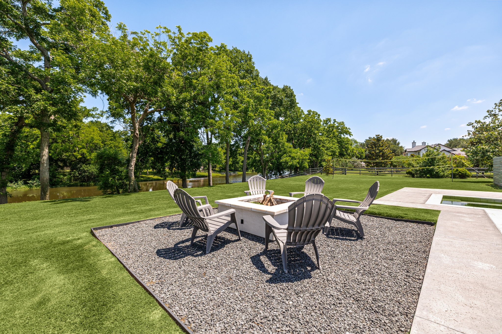 4311 Upper Oxbow Trace Fulshear, TX 77441 - Photo 43 of 49 Relax around the custom fire pit area overlooking the lush green space and peaceful water views.