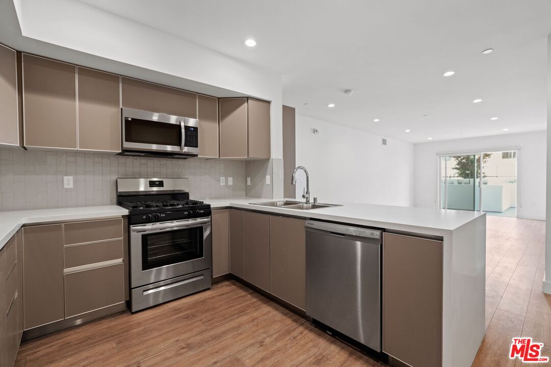 130 South Croft Avenue, Unit 201 Los Angeles, CA 90048 - Photo 3 of 14 a kitchen with stainless steel appliances granite countertop a sink and a stove top oven