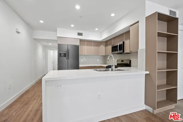 a kitchen with stainless steel appliances a refrigerator and a stove top oven