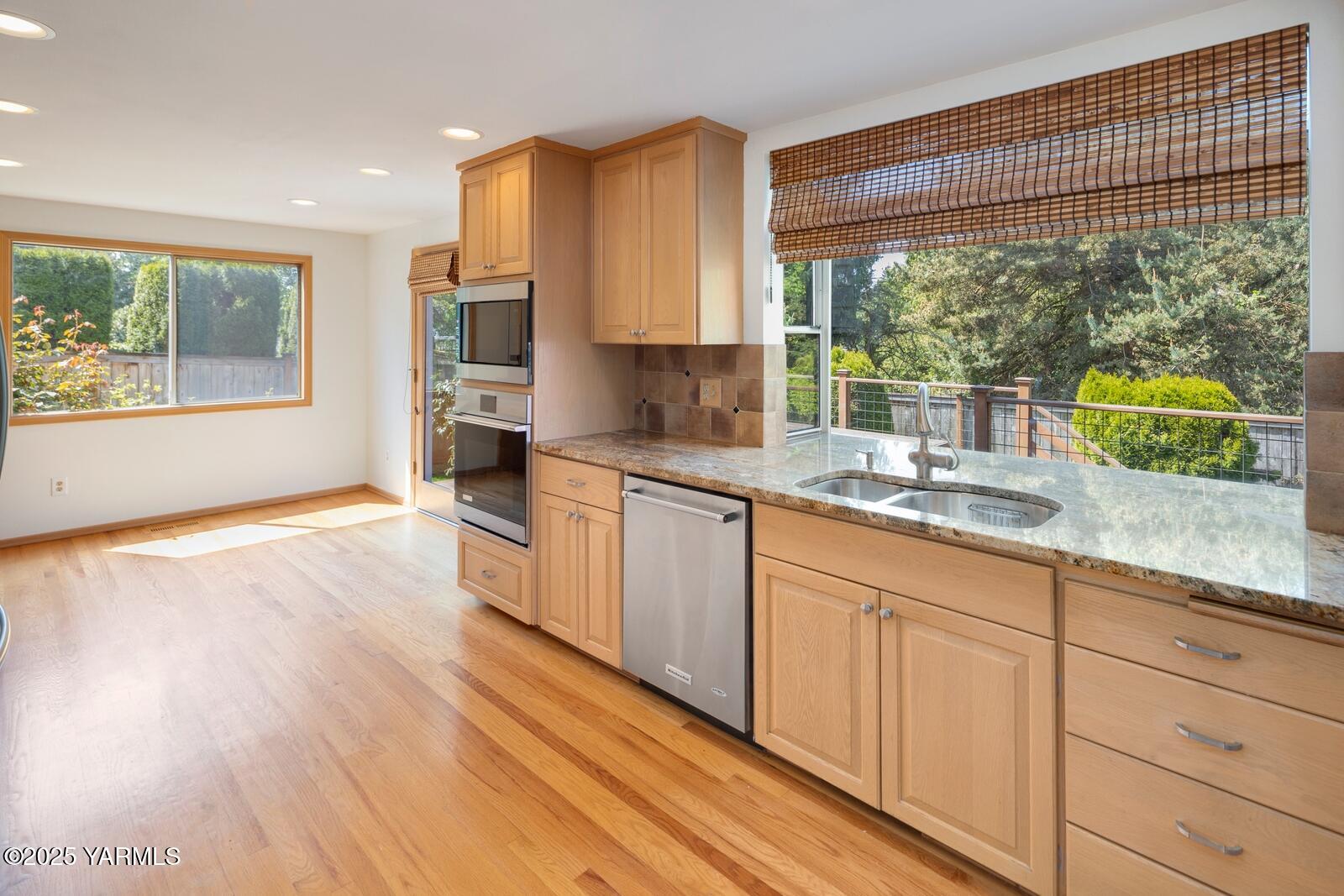 23812 21st Drive Southeast, Unit SE Bothell, WA 98021 - Photo 12 of 37 a kitchen with granite countertop wooden floors white cabinets and a large window