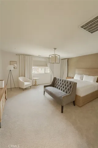 a bedroom with a bed chair and white walls