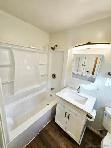 a bath tub sitting next to a blue sink and a rug
