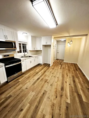 a large kitchen with granite countertop a stove a sink and a microwave