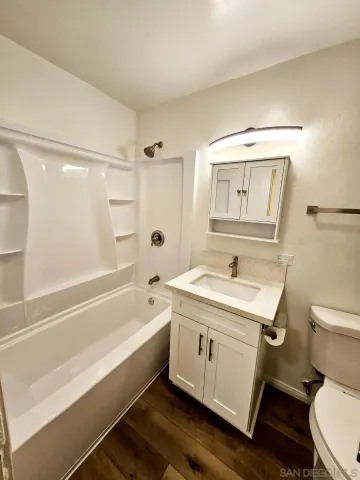 a bathroom with a granite countertop toilet a sink and bathtub