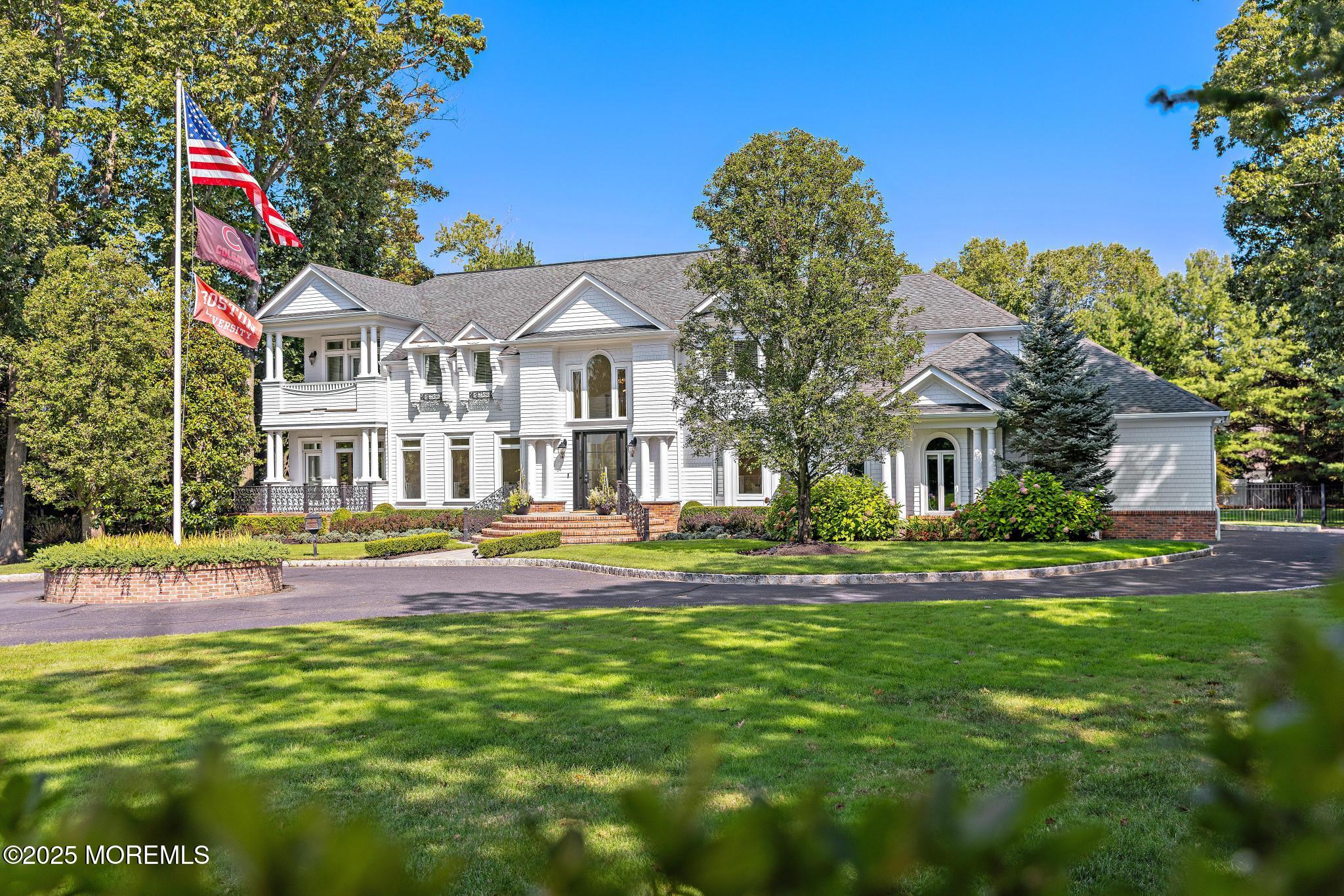 129 Ave Of Two Rivers Rumson, NJ 07760 - Photo 3 of 55 a front view of a house with a yard table and chairs