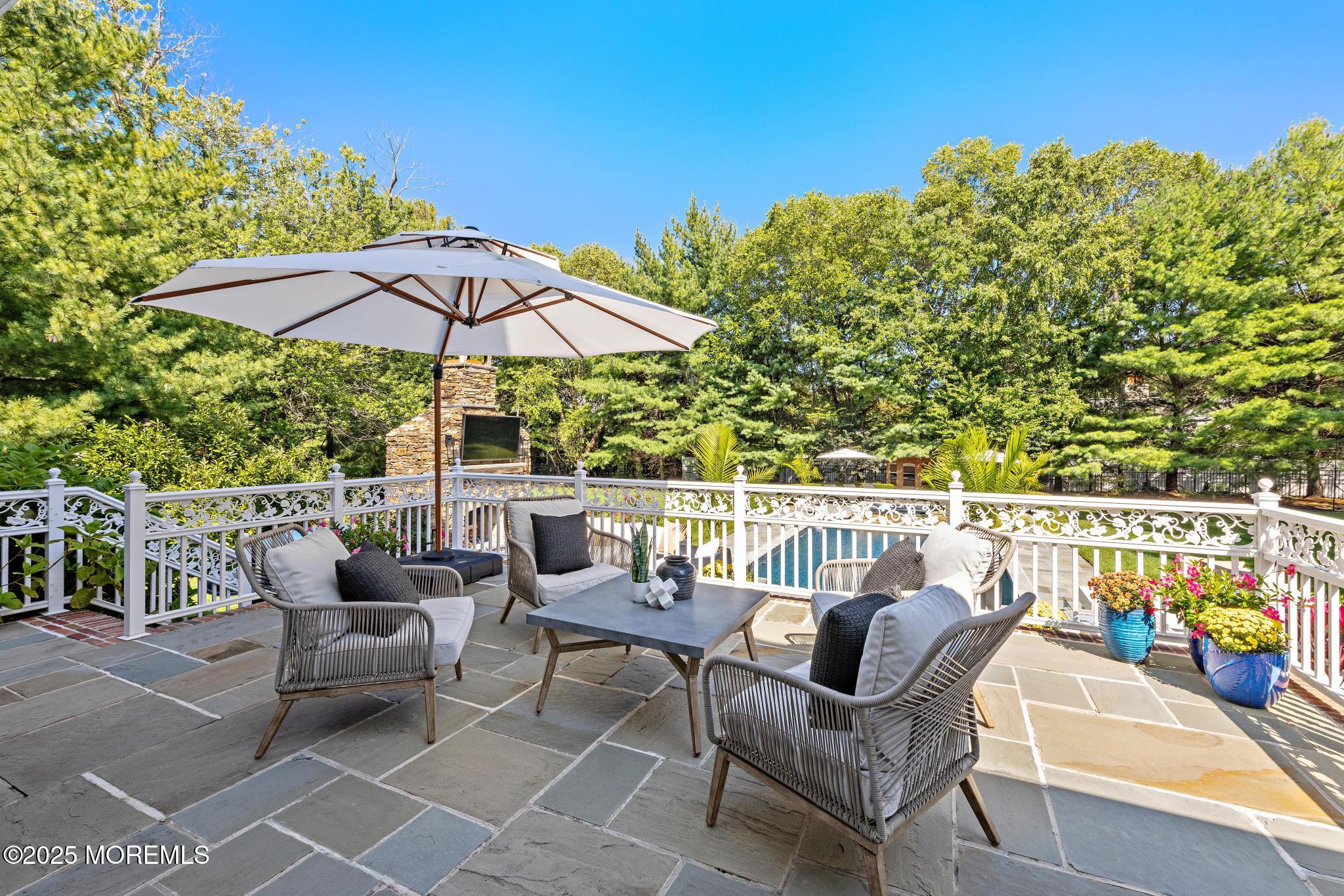 129 Ave Of Two Rivers Rumson, NJ 07760 - Photo 49 of 55 a view of a patio with couches chairs under an umbrella