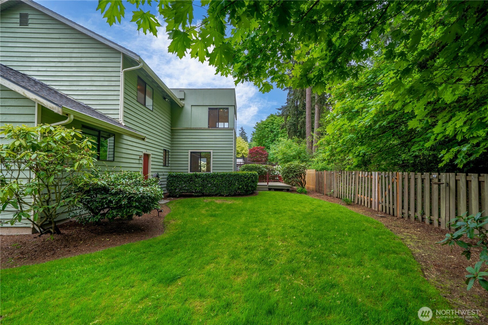 3811 South 255th Place Kent, WA 98032 - Photo 25 of 30 a view of backyard with potted plants and a wooden bench