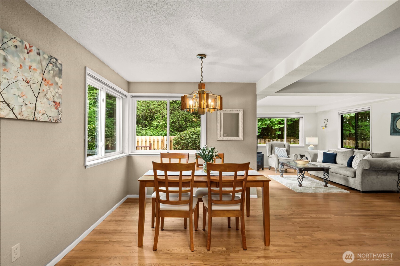 3811 South 255th Place Kent, WA 98032 - Photo 7 of 30 a dining room with wooden floor a chandelier a glass table and chairs