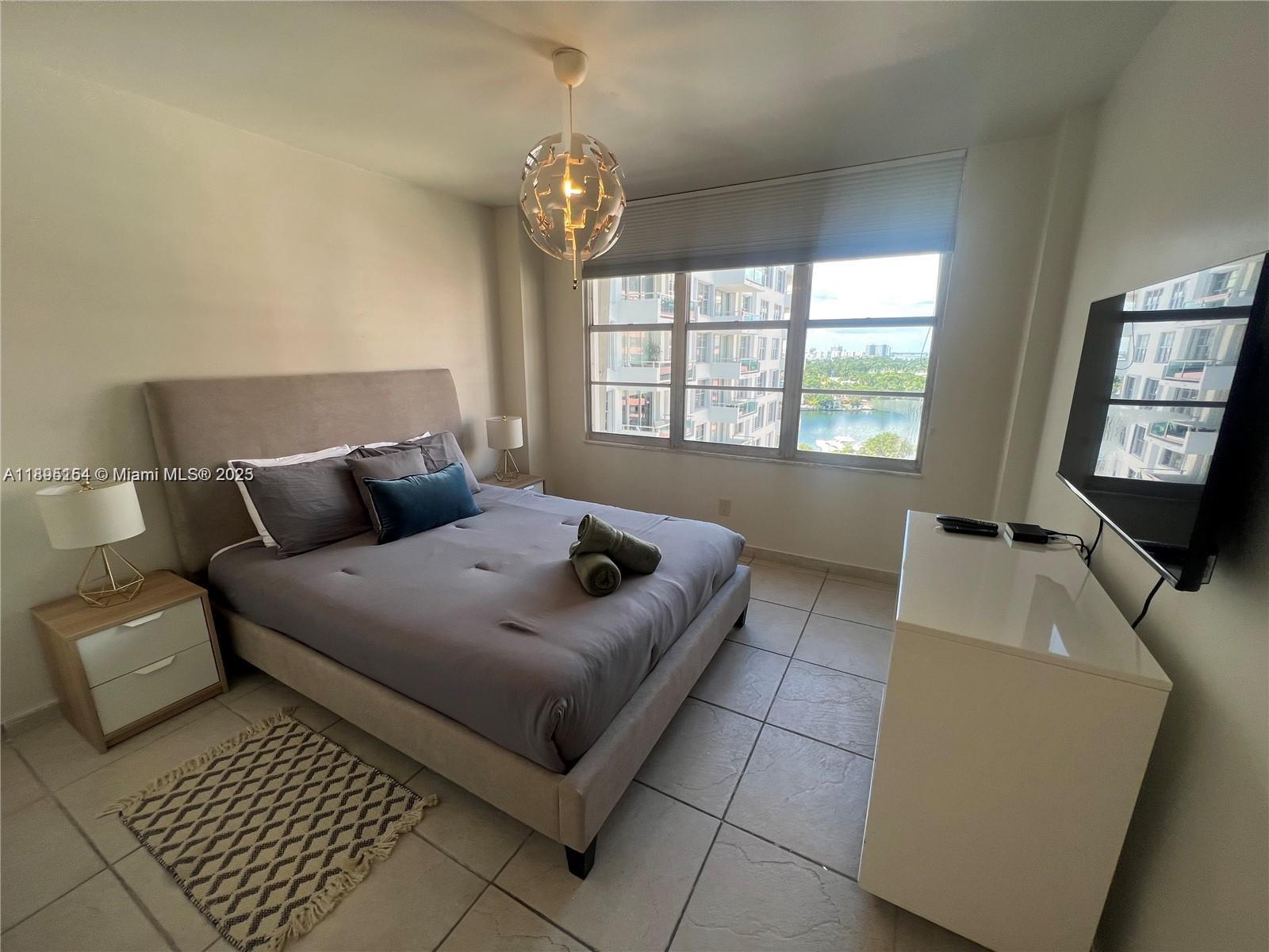 5161 Collins Avenue, Unit 1211 Miami Beach, FL 33140 - Photo 13 of 29 a living room with furniture and a flat screen tv