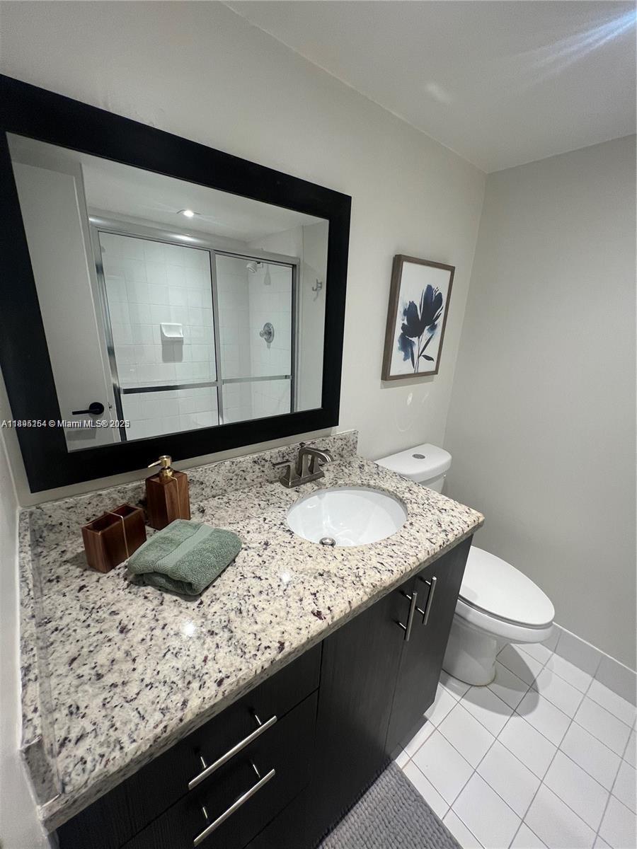 5161 Collins Avenue, Unit 1211 Miami Beach, FL 33140 - Photo 17 of 29 a bathroom with a granite countertop sink and a mirror