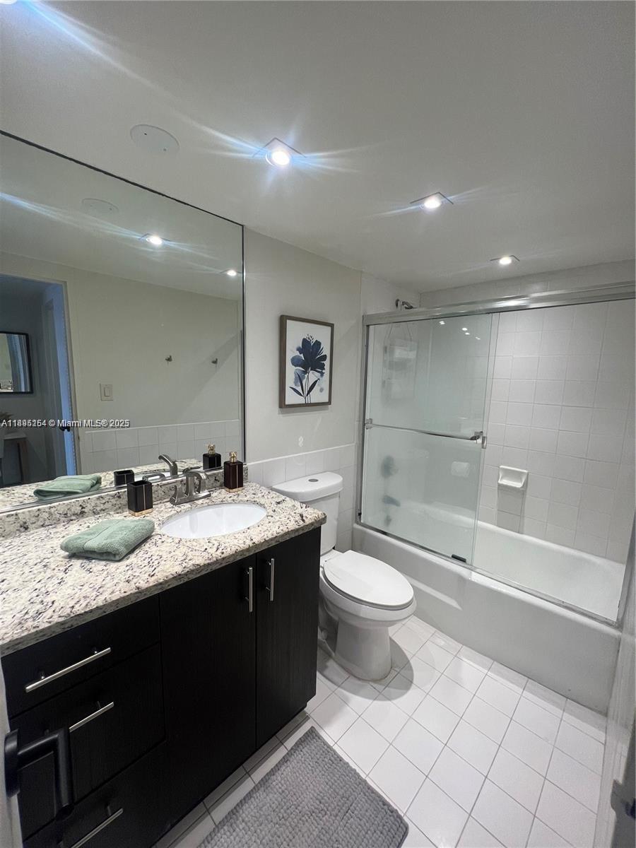 5161 Collins Avenue, Unit 1211 Miami Beach, FL 33140 - Photo 18 of 29 a bathroom with a granite countertop sink toilet and shower