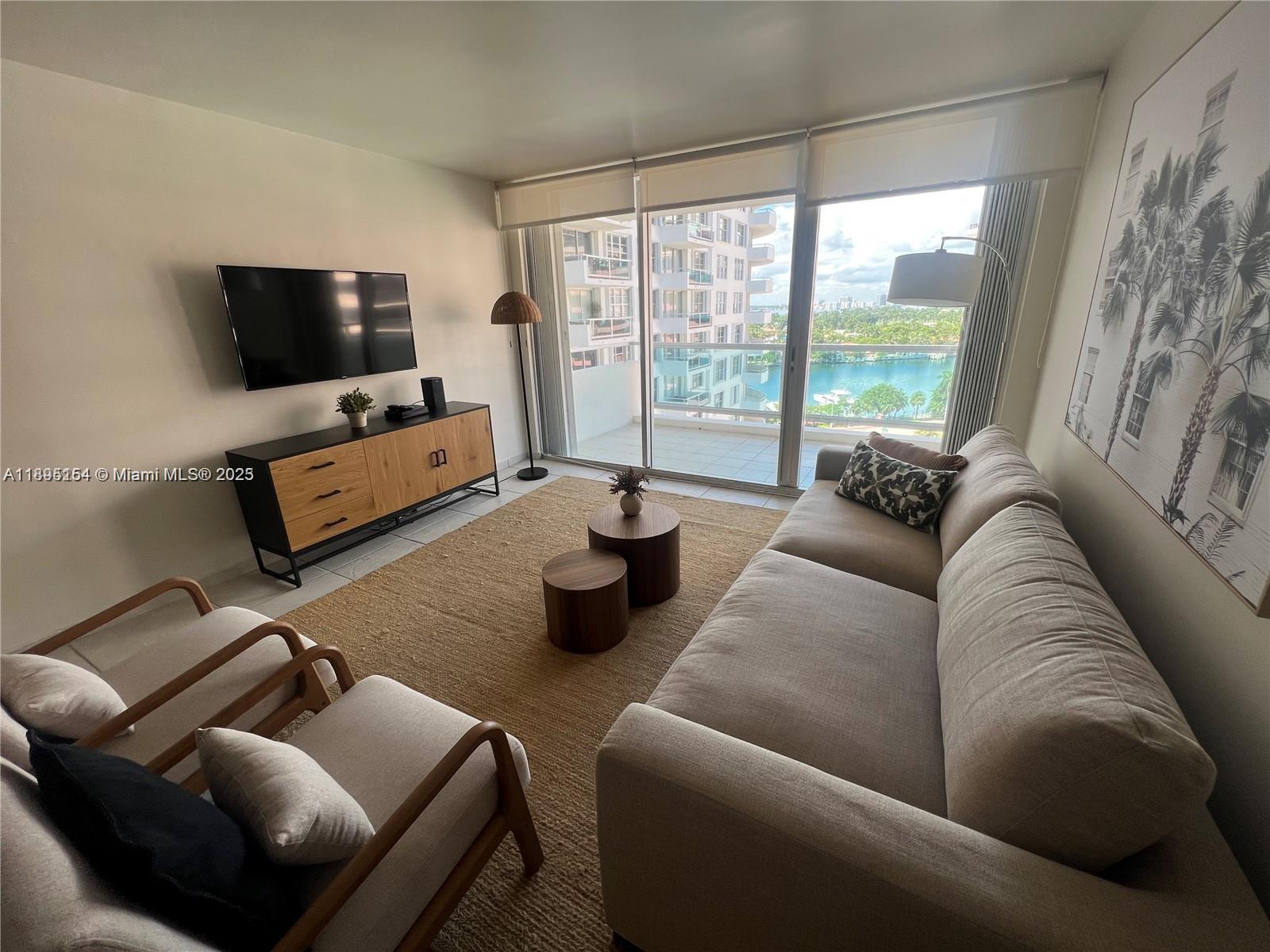 5161 Collins Avenue, Unit 1211 Miami Beach, FL 33140 - Photo 6 of 29 a living room with furniture and a flat screen tv