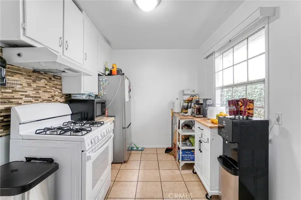 a kitchen with a refrigerator and a stove top oven