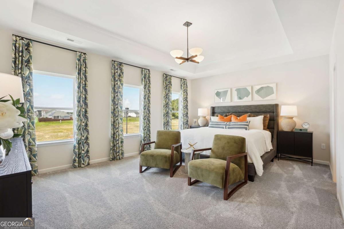 1441 Trellis Court, Unit (LOT 7) Hampton, GA 30228 - Photo 21 of 31 a bedroom with bed and a chandelier