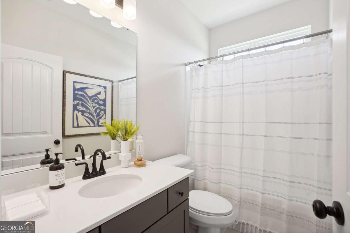 1441 Trellis Court, Unit (LOT 7) Hampton, GA 30228 - Photo 28 of 31 a bathroom with a sink toilet a mirror and shower