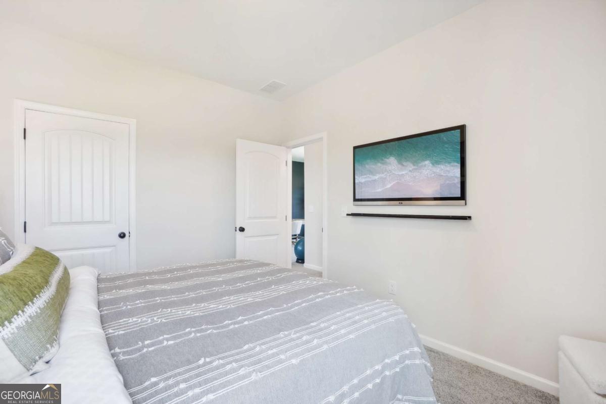 1441 Trellis Court, Unit (LOT 7) Hampton, GA 30228 - Photo 31 of 31 a bedroom with a bed and a painting on the wall