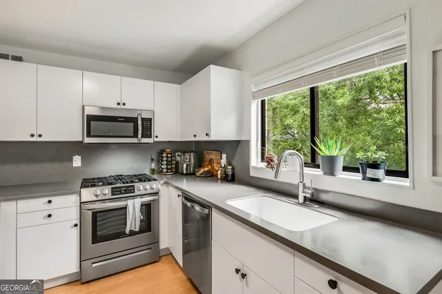 a kitchen with a sink stove top oven and cabinets