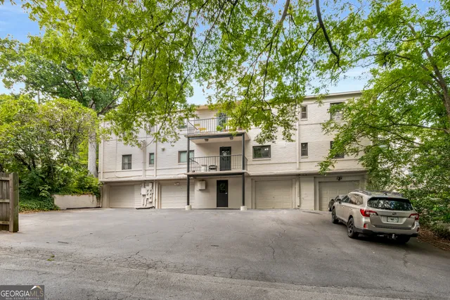 a view of a building with a lot of windows and a tree