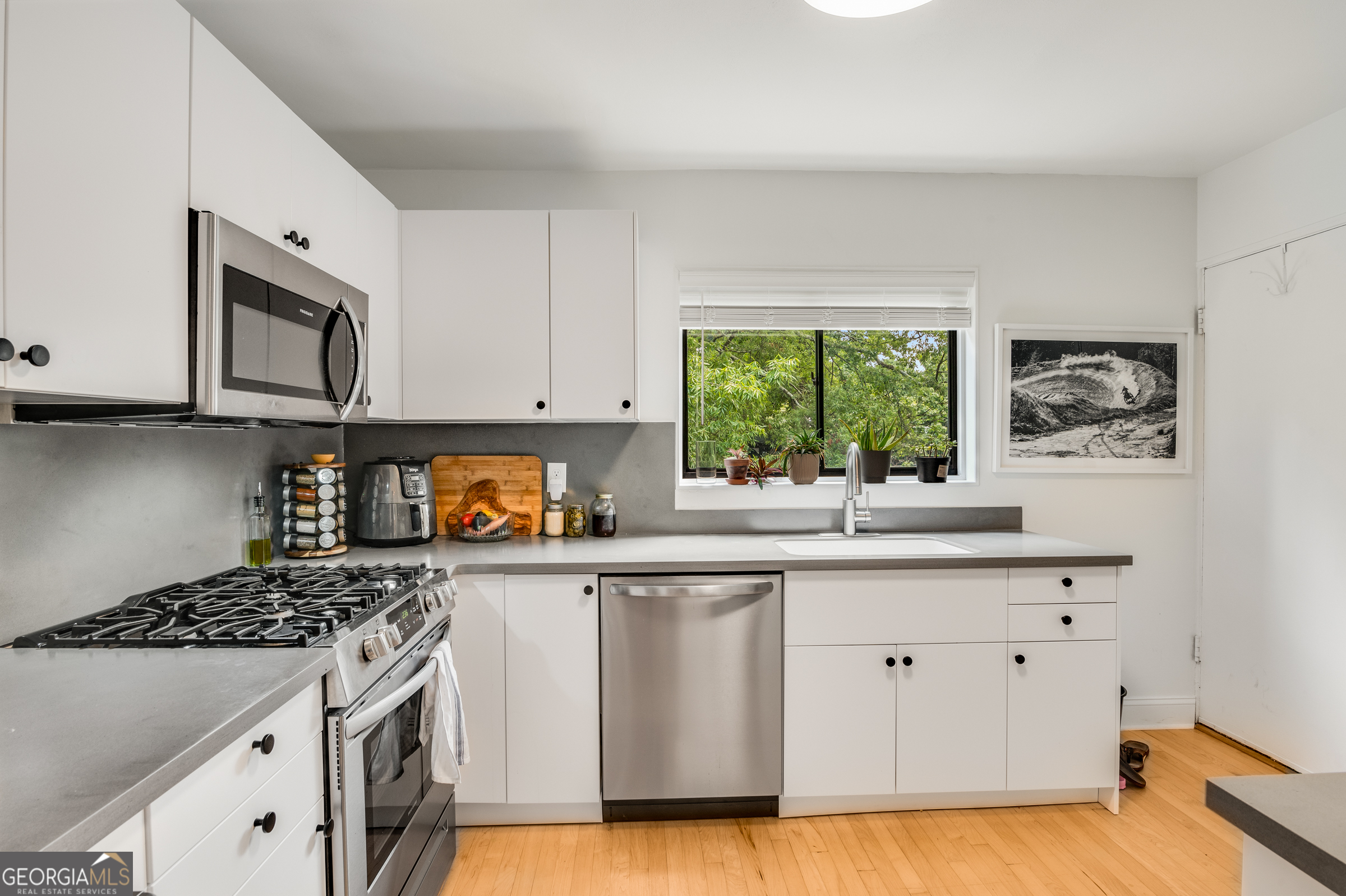 96 Ardmore Place Northwest, Unit 3 Atlanta, GA 30309 - Photo 8 of 24 a kitchen with granite countertop white cabinets and window