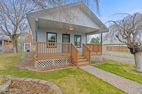 a view of a house with a small yard and wooden fence
