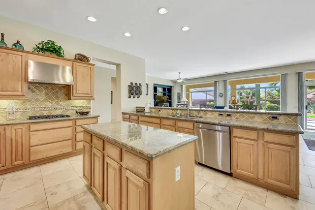 a kitchen with granite countertop a sink and cabinets