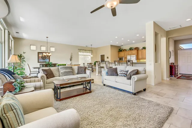 a living room with furniture kitchen view and a chandelier