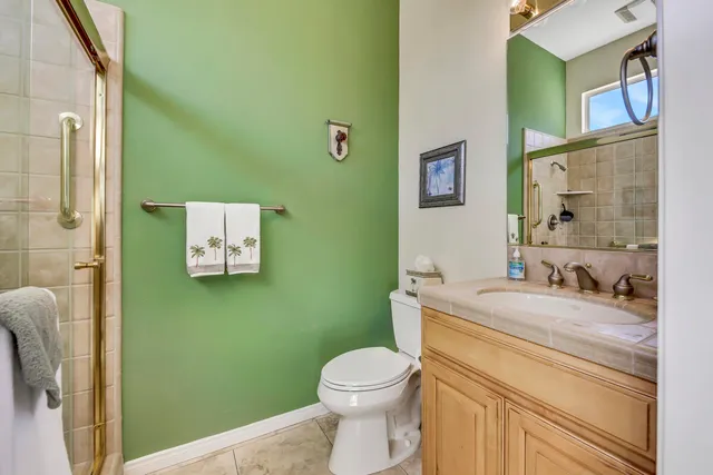 a bathroom with a granite countertop toilet sink and mirror