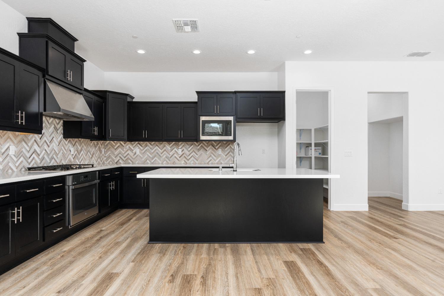 275 Huckleberry Road South Madera, CA 93636 - Photo 23 of 34 a large kitchen with stainless steel appliances kitchen island granite countertop a stove a sink and a microwave
