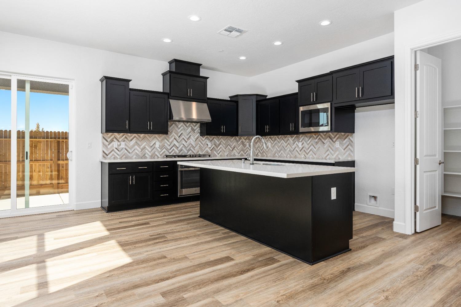 275 Huckleberry Road South Madera, CA 93636 - Photo 24 of 34 a kitchen with stainless steel appliances kitchen island granite countertop a large counter top and a wooden floors