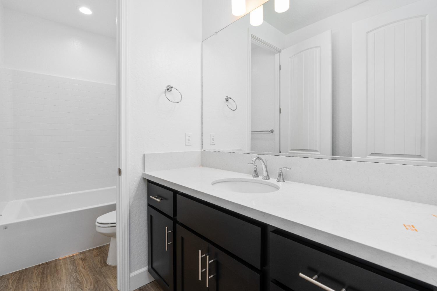 275 Huckleberry Road South Madera, CA 93636 - Photo 8 of 34 a bathroom with a granite countertop sink a toilet and a bathtub