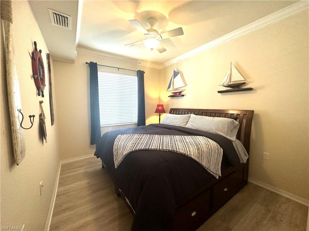 10353 Heritage Bay Boulevard, Unit 2226 Naples, FL 34120 - Photo 16 of 40 a bedroom with a bed and a chandelier