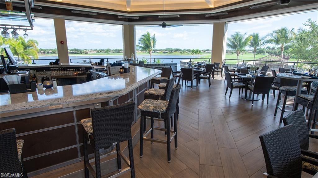 10353 Heritage Bay Boulevard, Unit 2226 Naples, FL 34120 - Photo 27 of 40 a dining table with chairs and wooden floor