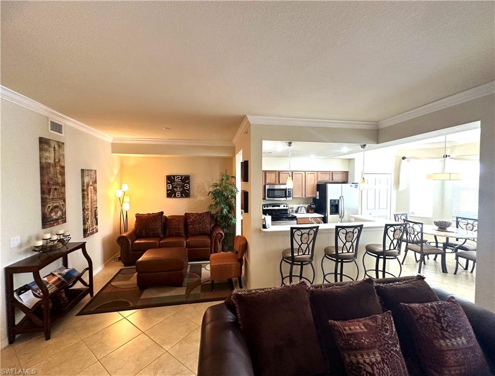 10353 Heritage Bay Boulevard, Unit 2226 Naples, FL 34120 - Photo 4 of 40 a living room with furniture and a large window