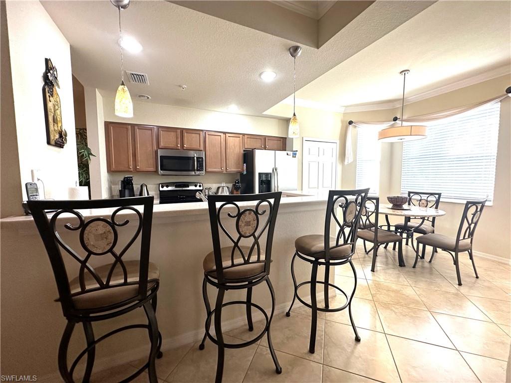 10353 Heritage Bay Boulevard, Unit 2226 Naples, FL 34120 - Photo 6 of 40 a view of a dining room with furniture