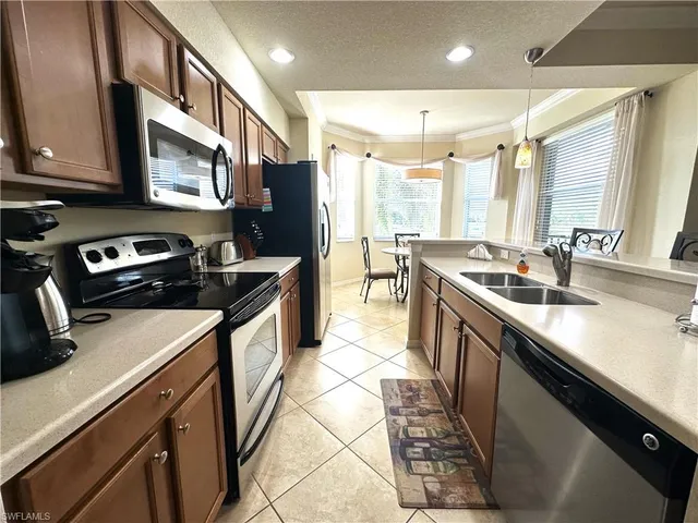 a kitchen with stainless steel appliances a sink stove and refrigerator