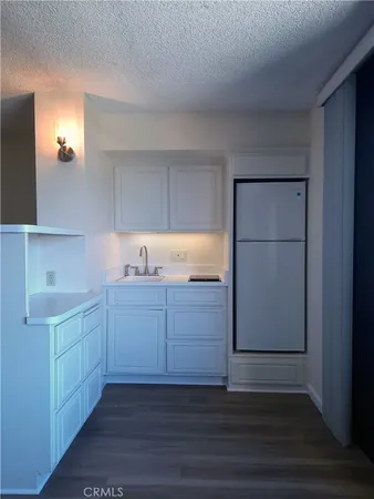 a kitchen with granite countertop white cabinets and sink