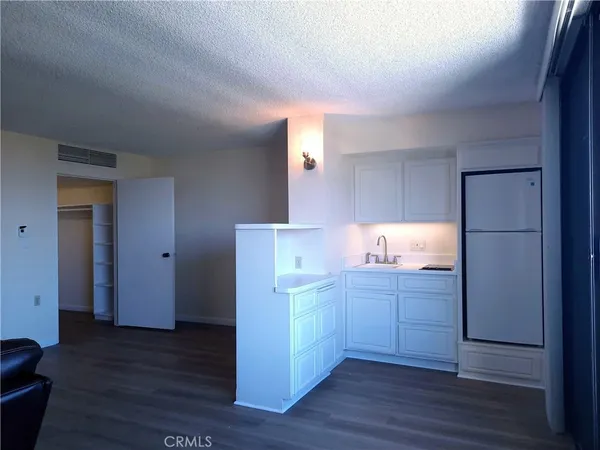 a kitchen with kitchen island wooden floors appliances and cabinets