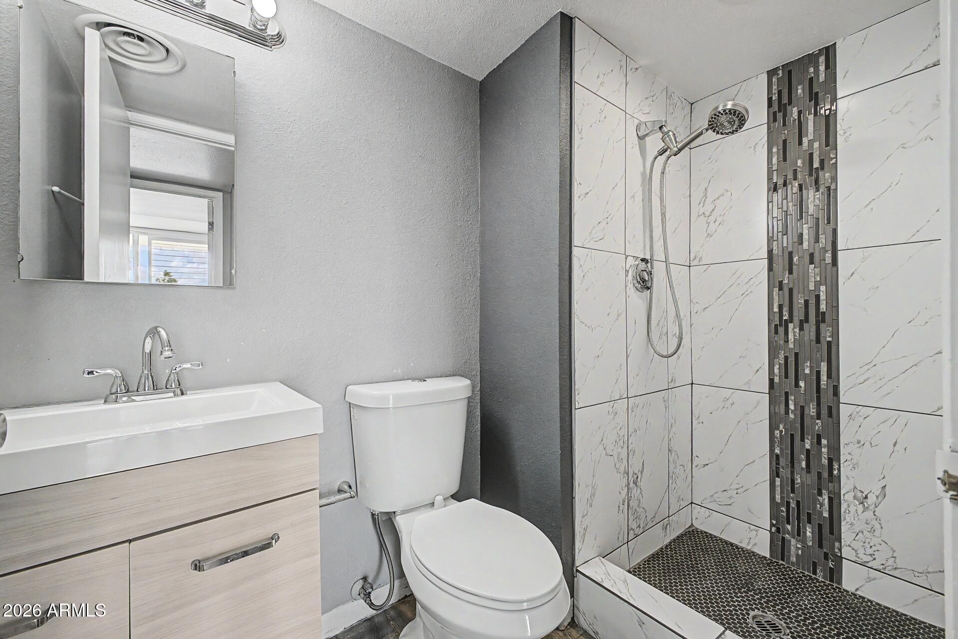 207 West Clarendon Avenue, Unit B2 Phoenix, AZ 85013 - Photo 15 of 30 a bathroom with a toilet sink vanity and shower