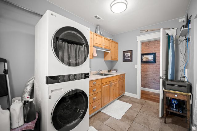 236 West 300 South Hurricane, UT 84737 - Photo 35 of 76 Dedicated utility room featuring stacked laundry appliances, light wood-finish cabinetry, a utility sink with a laminate countertop, tiled flooring, and a flush-mount ceiling light fixture