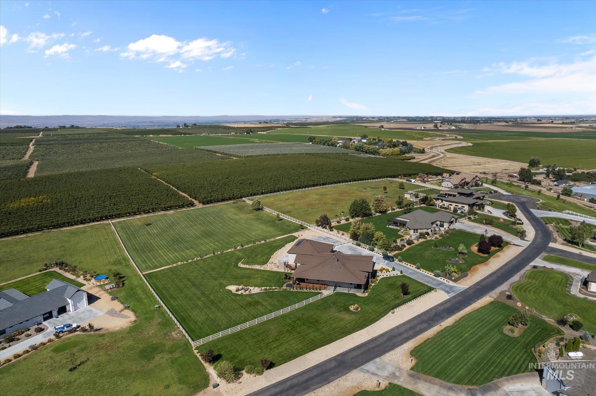 13683 Hockberger Ranch Road Caldwell, ID 83607 - Photo 42 of 50 Expansive property featuring a modern ranch-style residence, manicured lawns, paved driveway, and surrounding agricultural fields