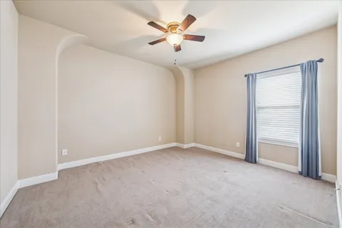 an empty room with closet and a ceiling fan