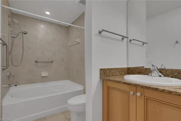 a bathroom with a granite countertop sink a toilet and shower