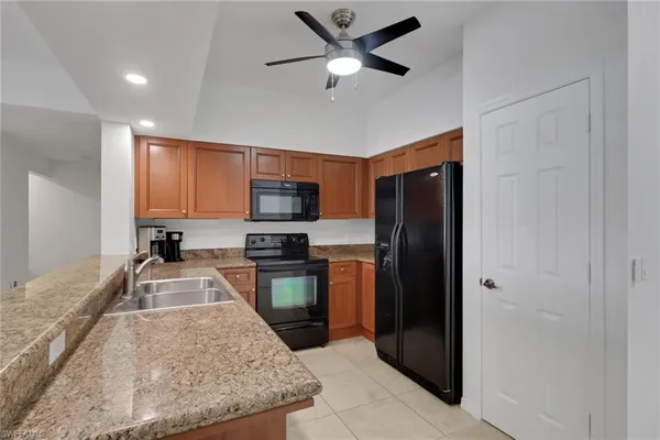 a kitchen with stainless steel appliances granite countertop a refrigerator a stove a sink a oven with a dining table and chairs