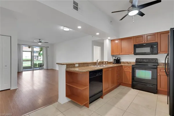 a large kitchen with stainless steel appliances granite countertop a stove and a sink