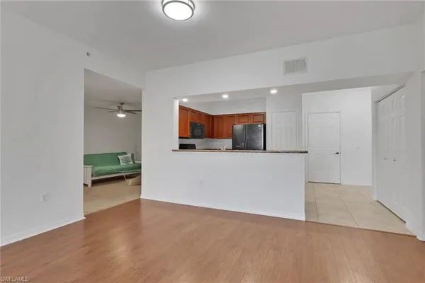 a view of a kitchen with a sink and dishwasher with wooden floor